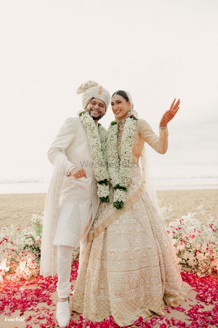 Happy couple portrait with stunning statement jaimalas in all white