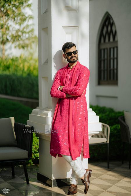 Groom portrait on the mehendi day with the groom in a bright pink mirrorwork kurta set