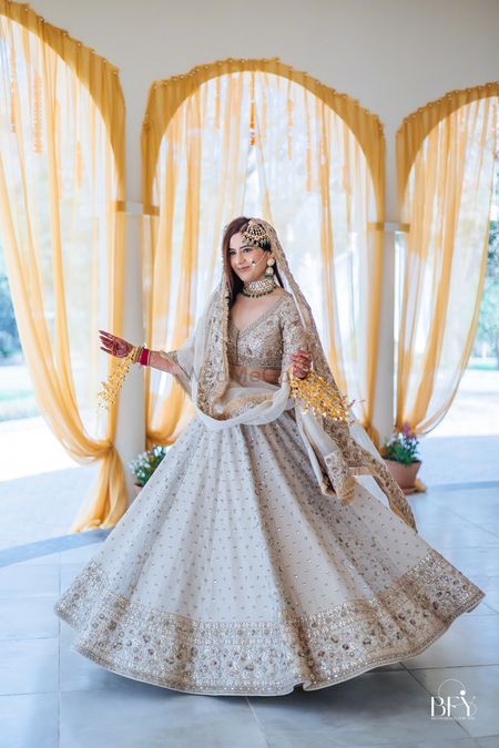 Twirling bride in ivory bridal lehenga with 