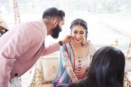 Photo of Candid shot of a bride and groom having fun on their Mehndi ceremony.