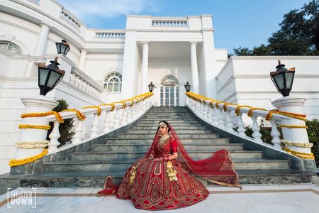 Bridal portrait on stairs with bride in red bridal lehenga 