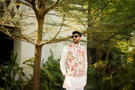 Groom in a floral print nehru jacket and white kurta pajama for the Mehndi 