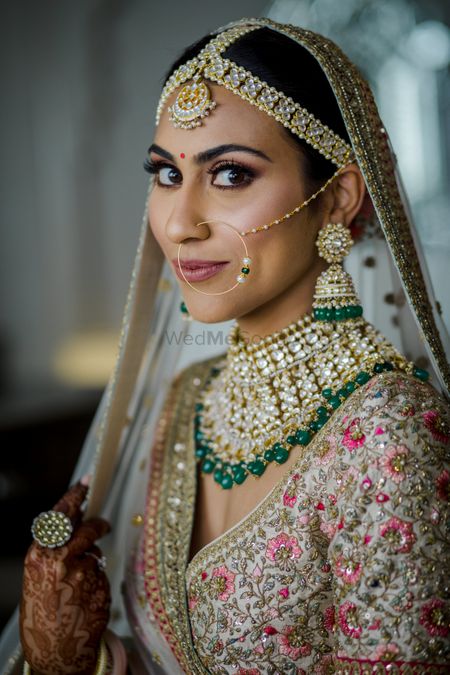 Pretty bride wearing an ivory lehenga with polki jewellery.