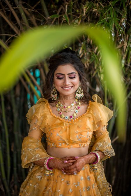 Mehendi bridal look inspiration with funky jewellery and ruffled blouse 