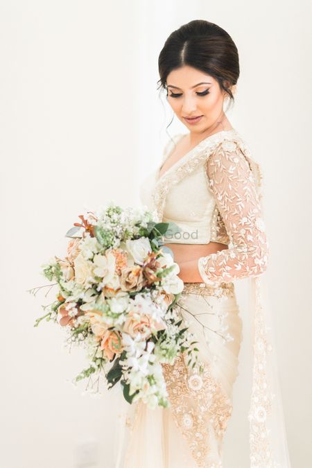 Bride in saree gown holding bouquet 