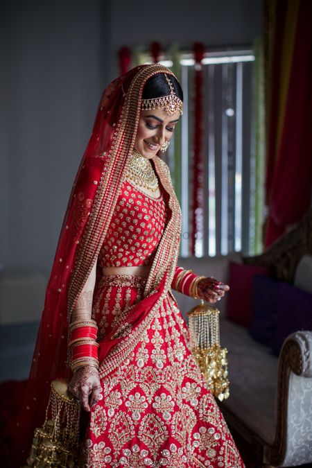 A bridal portrait on wedding day with the bride in a red Sabyasachi lehenga