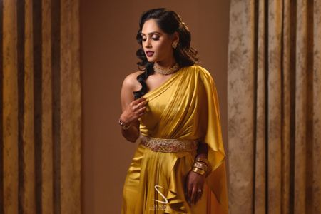 bride wearing a gold one shoulder gown and waistbelt 
