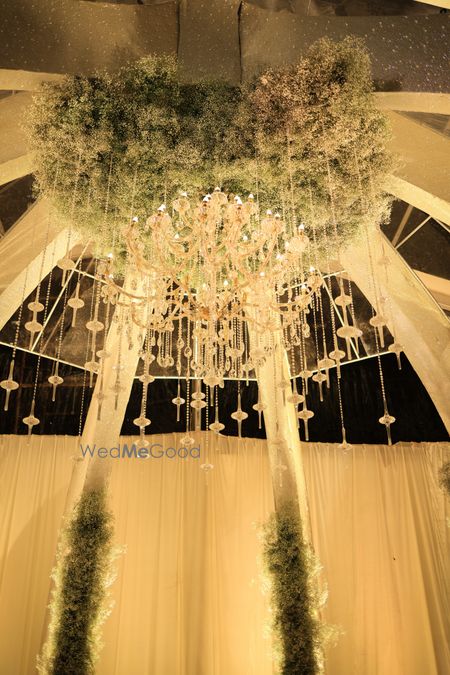 Photo of Gorgeous all white mandap with floral hanging chandelier and crystal elements for the wedding