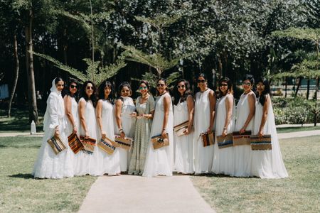 A bride poses with her bridesmaids in coordinated outfits 