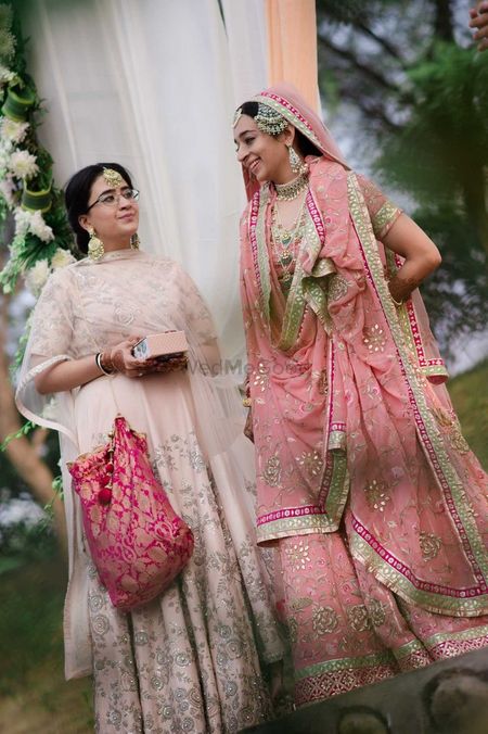Sikh bride in pastel pink sharar with bridesmaid