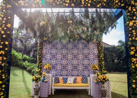 Unique Haldi seating with yellow, green, white and blue colored décor 