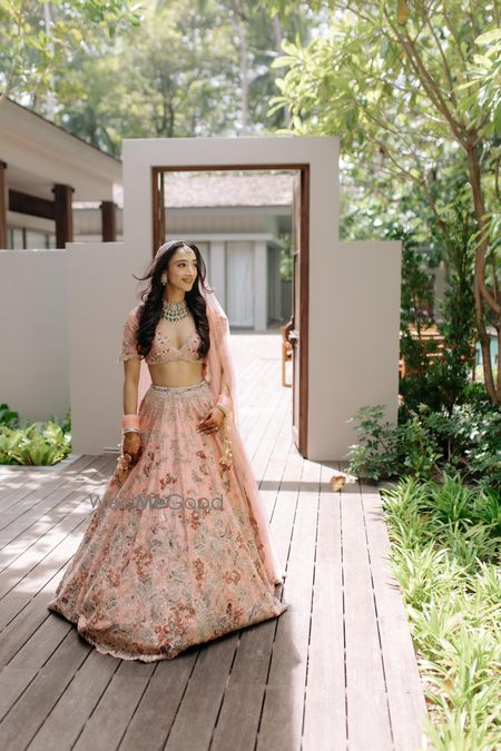 Lovely bridal portrait with bride in a peach pink pastel lehenga and baby pink chooda