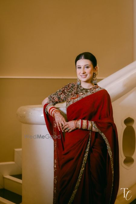 Photo of Gorgeous monotone red saree with a heavily studded blouse with a high neckline and sleek bun hairstyle