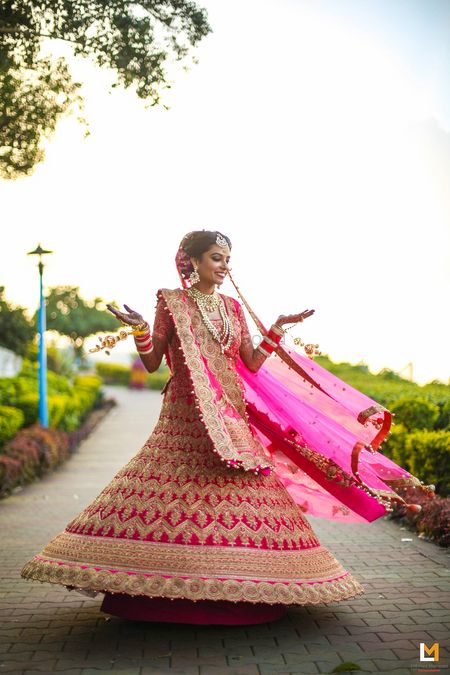 Photo of pink and gold twirling bridal lehenga