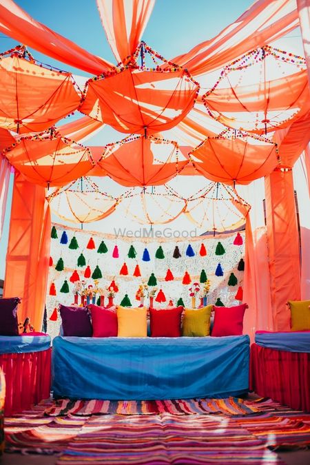 Colourful mehendi decor with tassels and hanging umbrellas