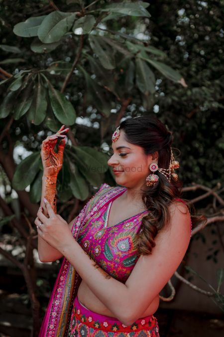 Bride-to-be on her Mehendi day flaunting her henna and hair accessories. 