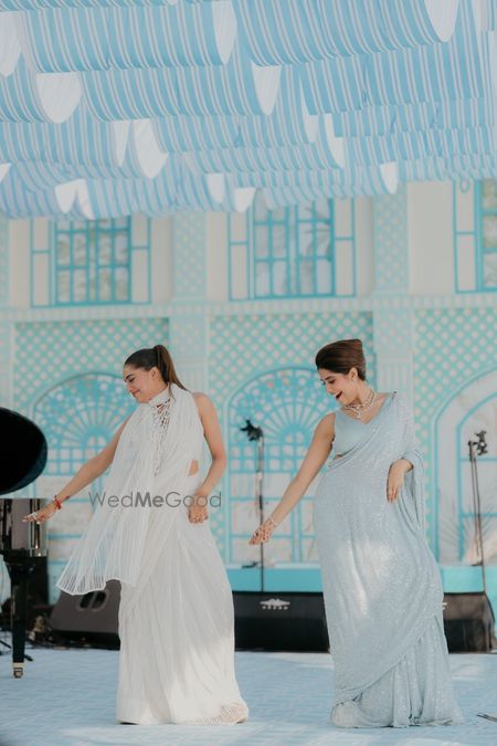 Photo of Bride and sister dancing in pastel outfits for the mehendi