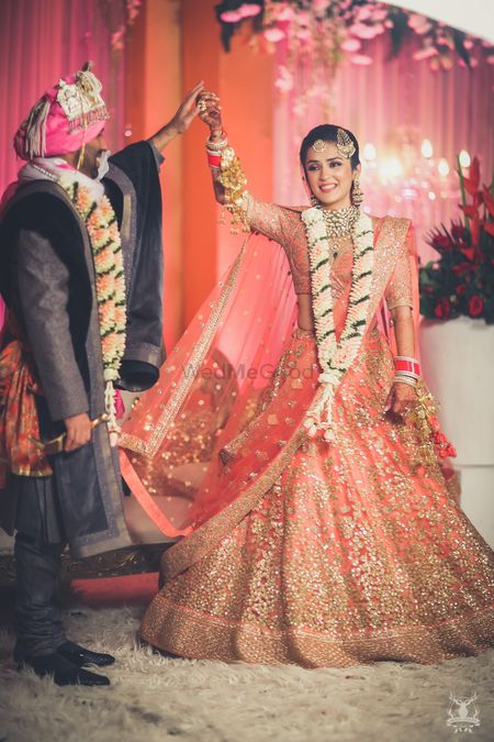 Photo of Peach and gold bridal lehenga on stage