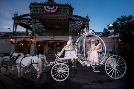 Indian bride and groom sit inside a carriage on their destination wedding at Disney World, Orlando