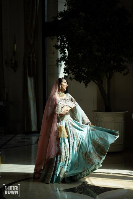 Photo of Bride in an offbeat light blue lehenga with a pink head dupatta