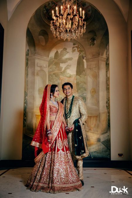 Photo of Red Sabyasachi bridal lehenga and groom