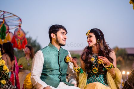 Matching bride and groom couple shot on mehendi wearing dark green