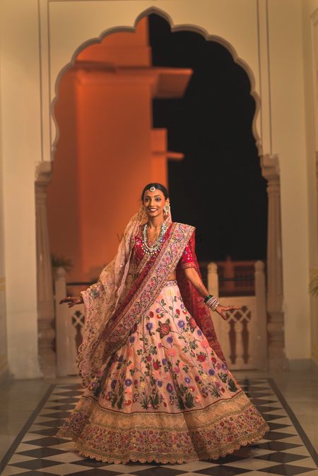 A bride in a custom-made lehenga twirling happily