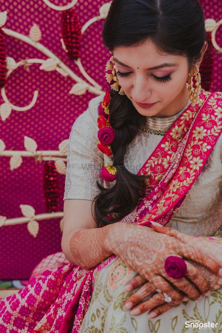 A bride in a pink and grey outfit for her haldi