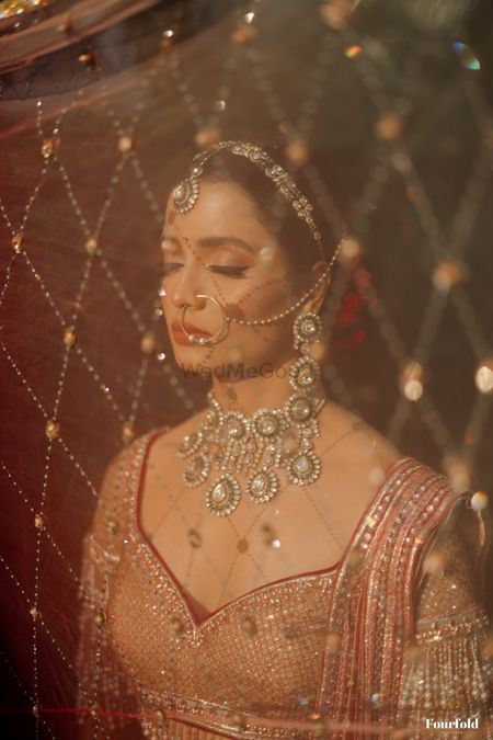 Photo of Stunning bridal shot with a sheer dupatta as a veil