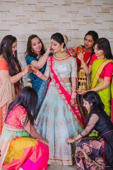 Photo of A bride in blue lehenga wit her bridesmaids