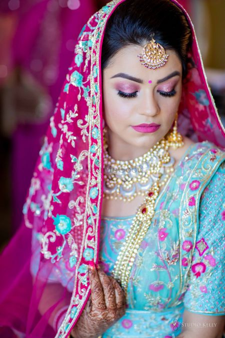 bride with light pink makeup and enamel jewellery