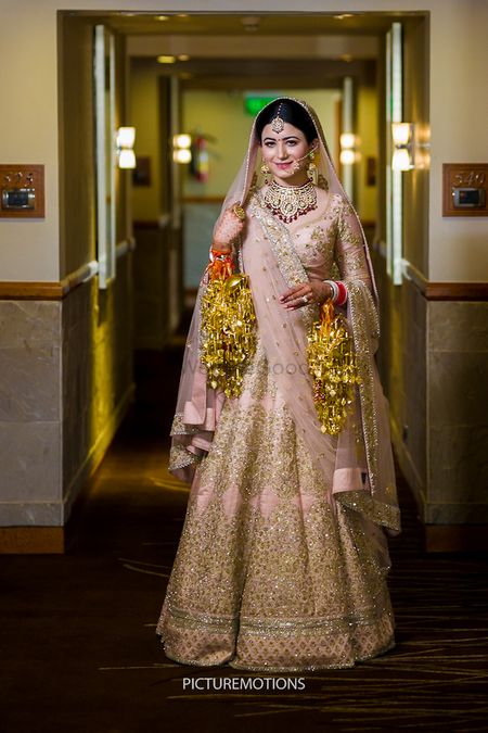 Photo of Light pink and gold bridal lehenga with kaleere