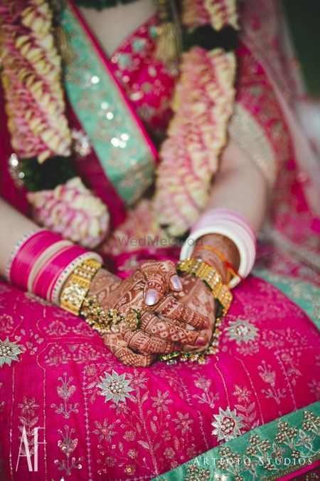 Bridal hands with green and gold haathphool