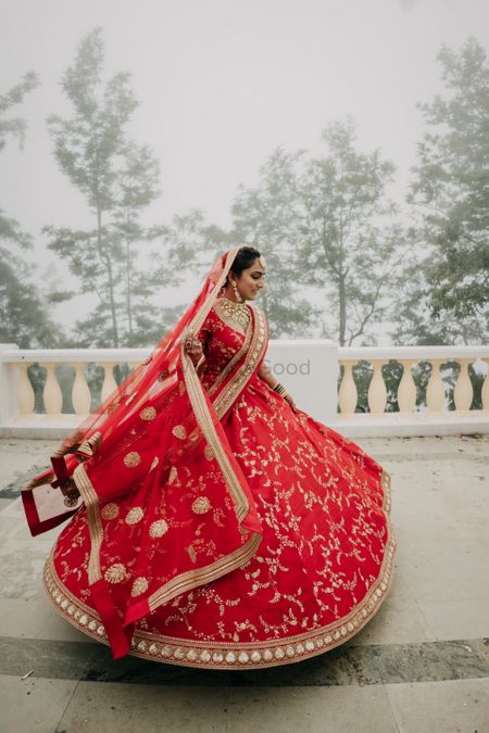 Bride twirling in a red Sabyasachi lehenga 