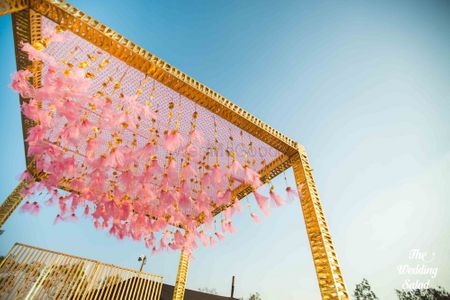 Light pink and gold mandap with hanging tassels 