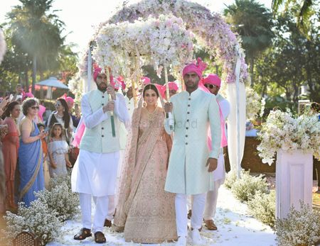 A bride enters under a gorgeous floral phoolon ki chaadar 