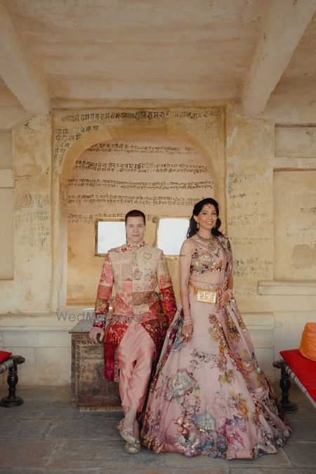 Lovely couple shot in a palace set up with the bride in a floral lehenga and groom in a multicoloured ensemble