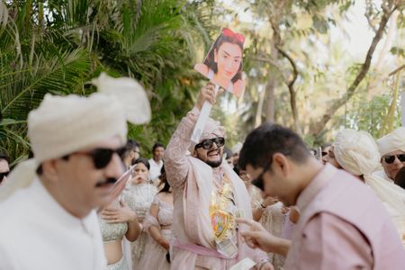 Super fun groom entry with bride's photos as a prop for the baraat