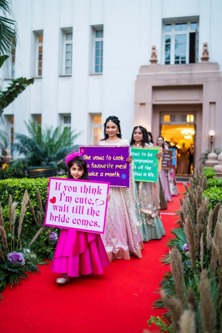Photo of Bridesmaids carrying cute quotes before the bridal entry
