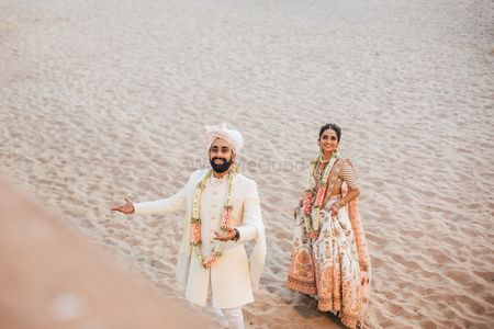Matching bride and groom portrait against sand 