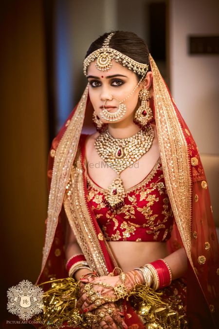 Photo of Bride in red floral embroidery lehenga and matching jewellery