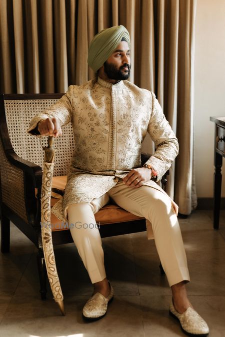 Photo of Stylish groom in an ivory sherwani with a pastel safa on his wedding day