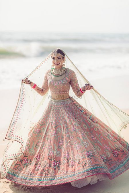 Photo of A gorgeous twirling shot of the bride on the beach