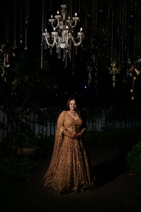 Bride on her cocktail in a gold lehenga