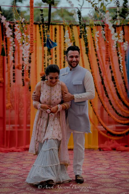 Photo of A bride in a perfectly coordinated sharara with the groom's blue kurta for their mehndi