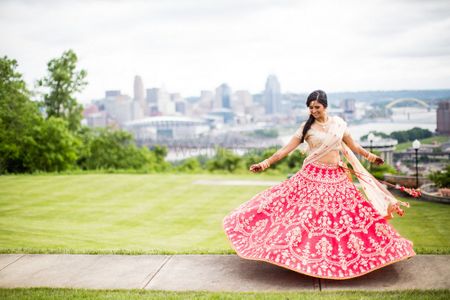 Bride twirling in red and gold gota patti lehenga
