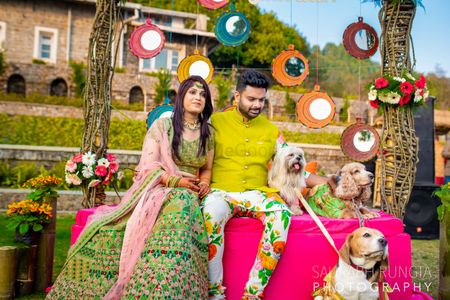 A bride and groom pose with their dogs at their mehendi