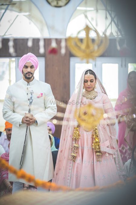 Celebrity couple Angad Bedi and Neha Dhupia in color coordinated outfits at their anand karaj