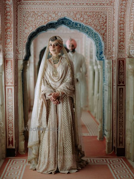 Photo of Royal bride and groom portrait with bride in a chikankari lehenga and emerald jewellery