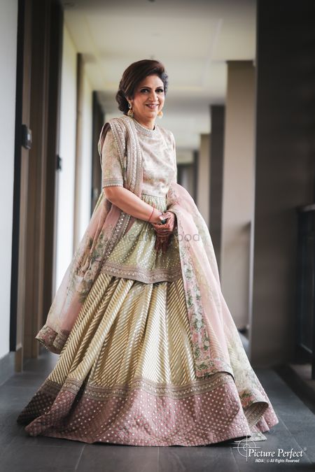 Photo of stylish mother of the bride in a pastel lehenga